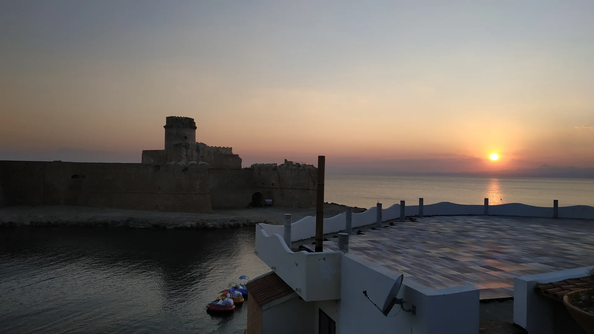 La fortezza aragonese di Le Castella e il mare Ionio al tramonto.